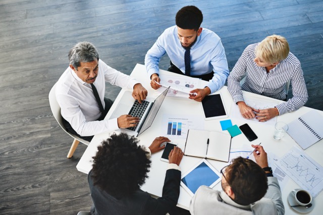 Company, meeting and graph for people, laptop and research for startup, online and top view of team. Collaboration, discussion and internet for news in boardroom, budget analyst and app for plan